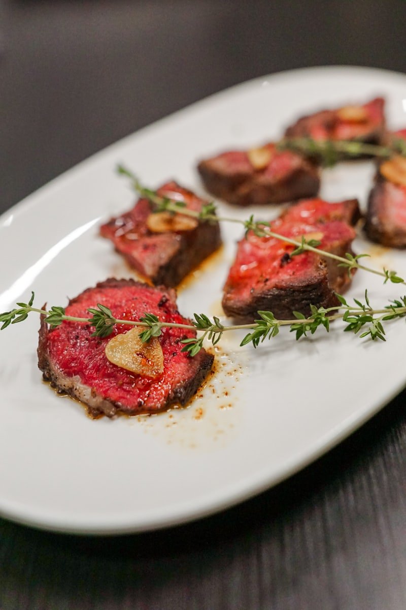A protein-forward plate of sliced grilled steak with chimichurri